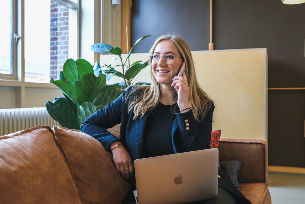 Geschäftsfrau mit Laptop am Telefon, symbolisiert professionelle Beratung und individuelle Lösungen in der Lohn- und Gehaltsabrechnung. Darstellung moderner Kommunikation und Effizienz bei der Unterstützung von Unternehmen im Faktorverfahren. Ideal für Inhalte zu Lohnbuchhaltung, Steueroptimierung und persönlichem Service.
