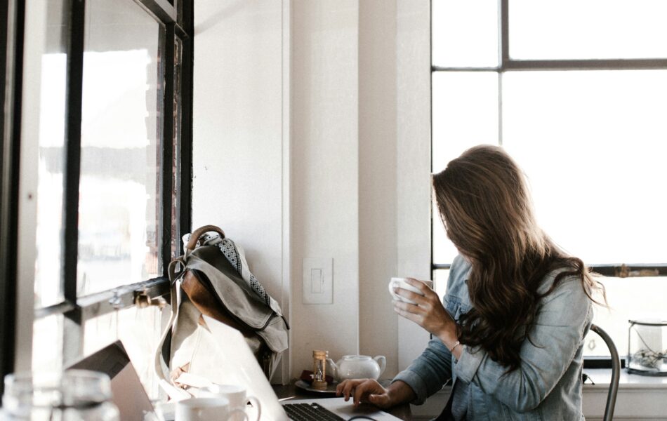 Eine junge Frau arbeitet mit ihrem Laptop in einem Café, symbolisiert die flexible Arbeitsweise von Freelancern und Selbstständigen. Das Bild steht exemplarisch für das Thema Scheinselbstständigkeit und die Abgrenzung zwischen freier Tätigkeit und abhängiger Beschäftigung. Es eignet sich ideal für Beiträge zur rechtlichen Einordnung, den Risiken für Unternehmen und die Bedeutung der korrekten Lohnabrechnung.