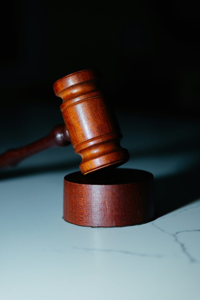 Holzrichterhammer auf einem Tisch, symbolisiert die rechtlichen Konsequenzen der Scheinselbstständigkeit für Unternehmen und Auftragnehmer. Dieses Bild eignet sich ideal für Beiträge zu rechtlichen Risiken, Prüfverfahren und Compliance-Maßnahmen in der Lohnbuchhaltung. Es betont die Bedeutung einer korrekten Abgrenzung zwischen Selbstständigkeit und abhängiger Beschäftigung
